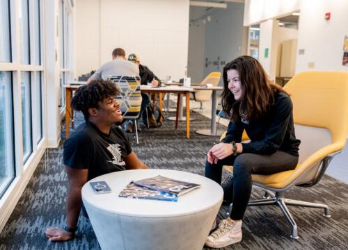 Two trinity college students conversing in a study lounge